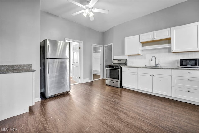 kitchen with decorative backsplash, dark wood finished floors, stainless steel appliances, white cabinetry, and a sink