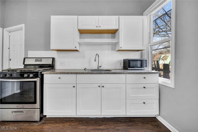 kitchen featuring stone countertops, appliances with stainless steel finishes, tasteful backsplash, and a sink