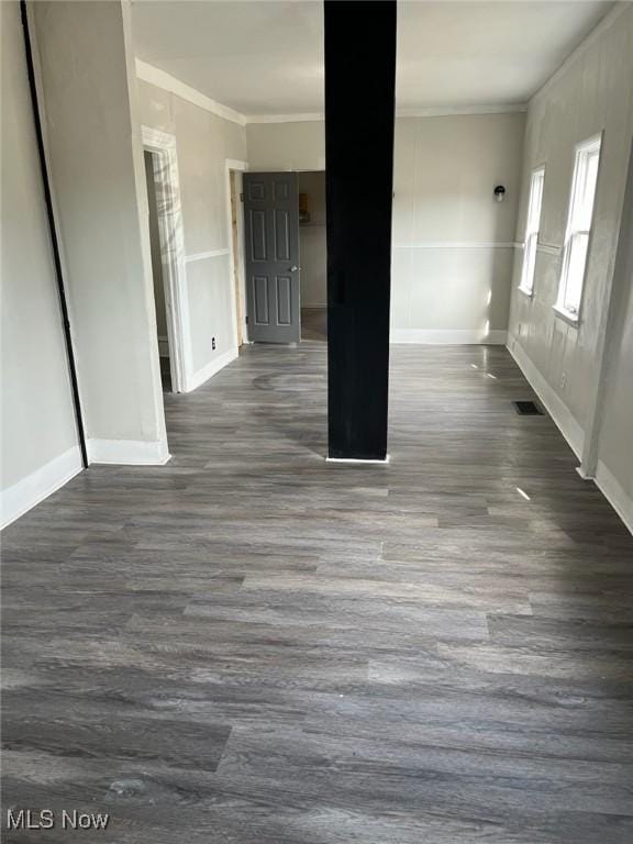 unfurnished room featuring dark wood-style floors, ornamental molding, visible vents, and baseboards