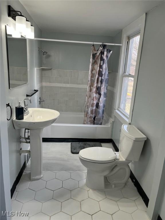 bathroom featuring shower / bath combo and toilet