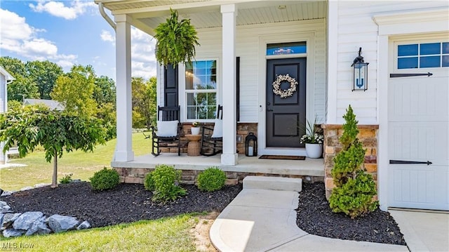 doorway to property with stone siding and a porch