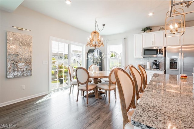 dining space featuring recessed lighting, a notable chandelier, dark wood finished floors, and baseboards