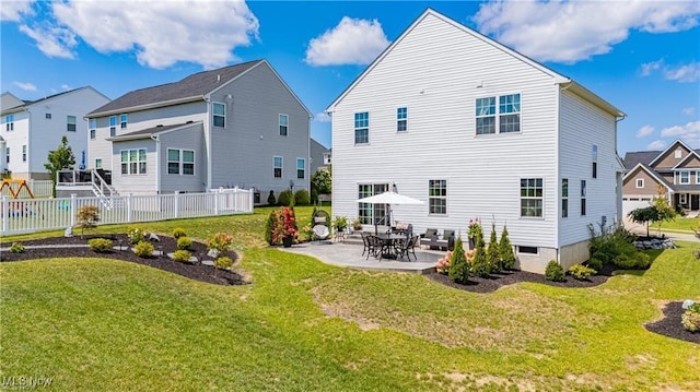 rear view of property featuring a lawn, a patio area, and fence