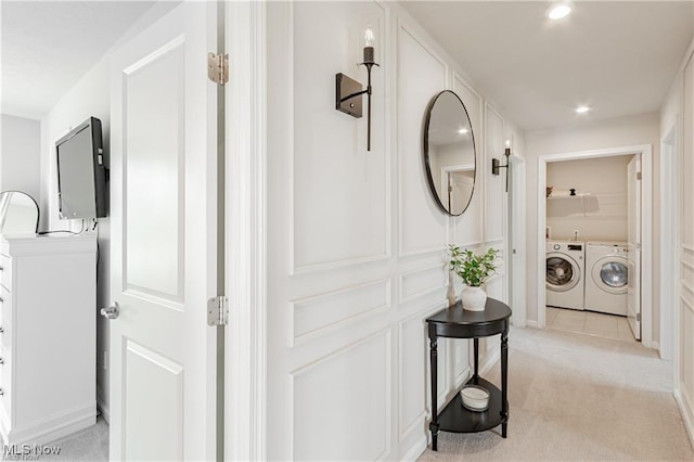 hall with light carpet, washing machine and clothes dryer, and recessed lighting