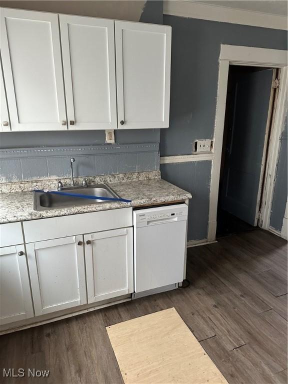 kitchen with dishwasher, dark wood-type flooring, a sink, and white cabinets