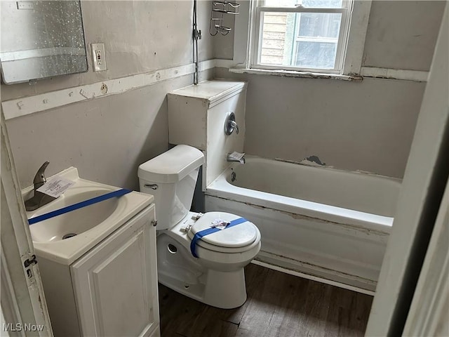 full bath with toilet, vanity, wood finished floors, and a bath