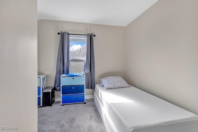 carpeted bedroom with lofted ceiling