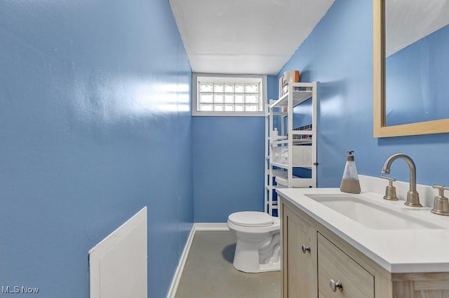 bathroom featuring vanity, toilet, and baseboards