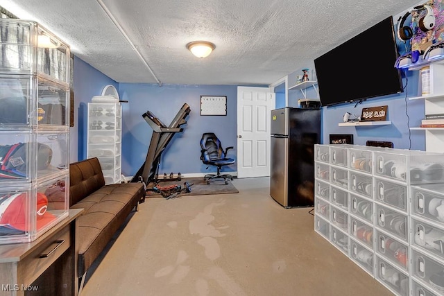 workout room featuring a textured ceiling and baseboards