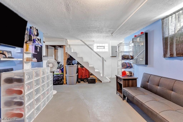 below grade area featuring electric panel, stairs, and a textured ceiling