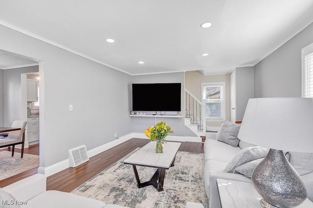 living area with recessed lighting, wood finished floors, visible vents, baseboards, and ornamental molding