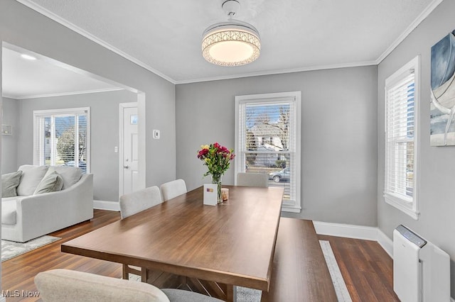 dining room with ornamental molding, plenty of natural light, wood finished floors, and baseboards