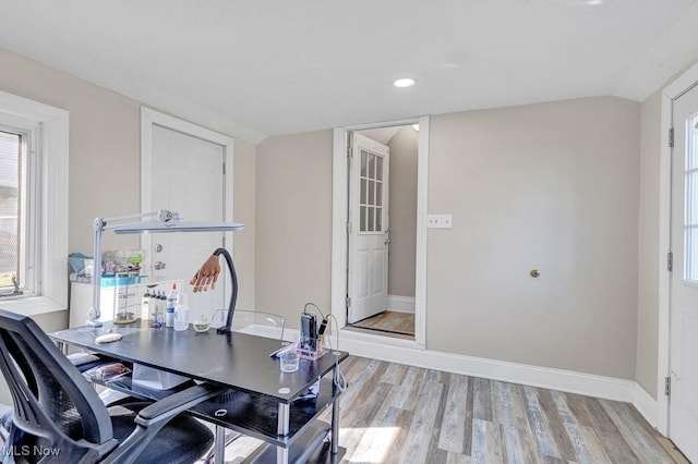 office with lofted ceiling, baseboards, and light wood finished floors