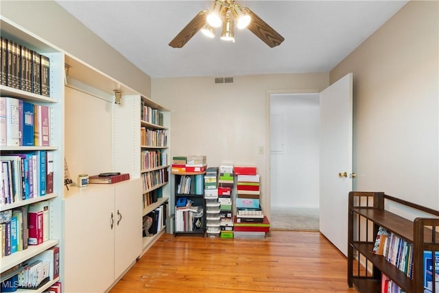 rec room with a ceiling fan, visible vents, and wood finished floors