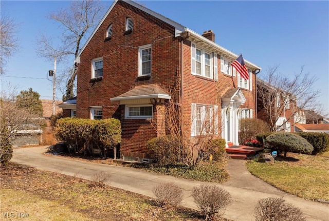 view of property exterior featuring a chimney and brick siding