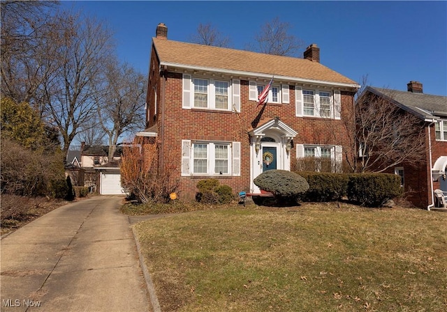 colonial home with brick siding, a chimney, and a front lawn