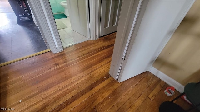 hall with hardwood / wood-style flooring and baseboards