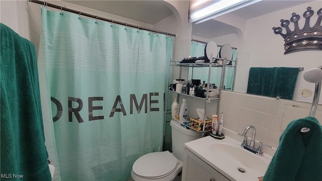 bathroom featuring curtained shower, toilet, vanity, tile walls, and backsplash