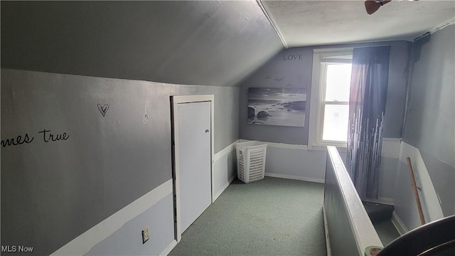 interior space with vaulted ceiling, carpet, and baseboards