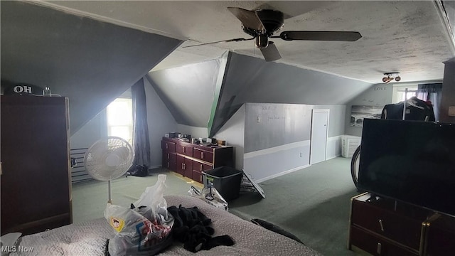 bedroom featuring lofted ceiling, a textured ceiling, a ceiling fan, and carpet flooring