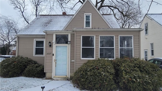 view of front of home featuring a shingled roof and a chimney