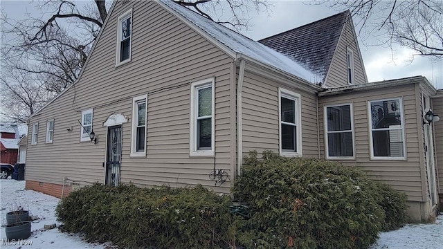 view of property exterior featuring crawl space and a shingled roof