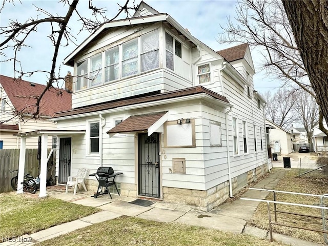 view of front facade with fence and a shingled roof