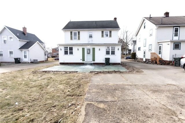 rear view of house with central AC and a patio