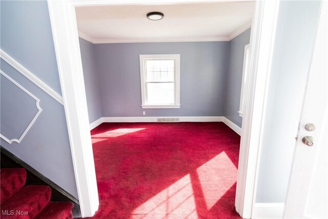 carpeted spare room with baseboards, stairs, visible vents, and crown molding