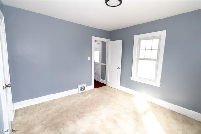 unfurnished bedroom with carpet, visible vents, and baseboards