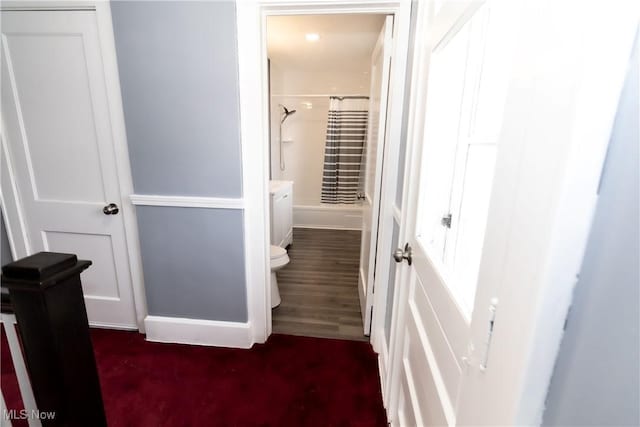 interior space featuring baseboards, toilet, and wood finished floors