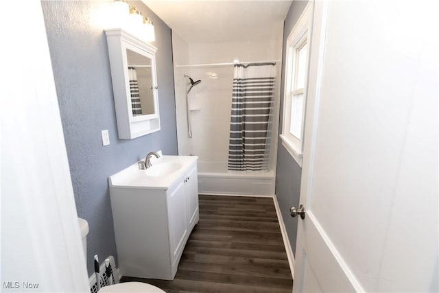 bathroom with wood finished floors, shower / bath combo, vanity, and toilet