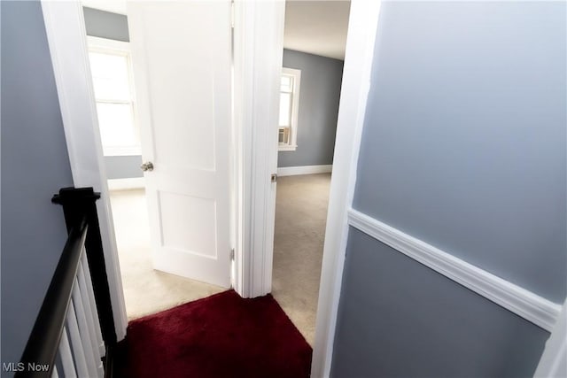 hallway with a wealth of natural light, carpet, and an upstairs landing