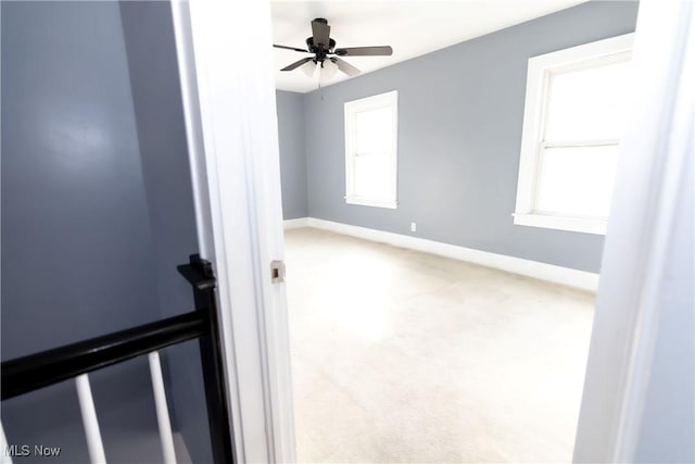 spare room featuring carpet, a ceiling fan, and baseboards