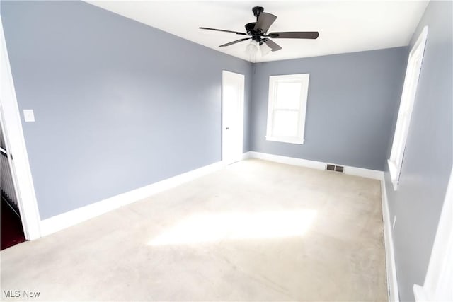 spare room with a ceiling fan, carpet flooring, visible vents, and baseboards