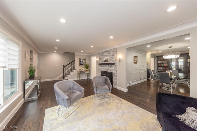 living room featuring recessed lighting, a fireplace, wood finished floors, stairs, and ornamental molding