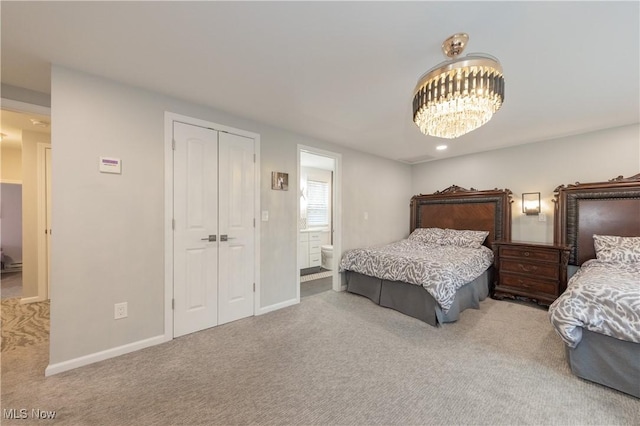 carpeted bedroom featuring an inviting chandelier, ensuite bath, baseboards, and a closet