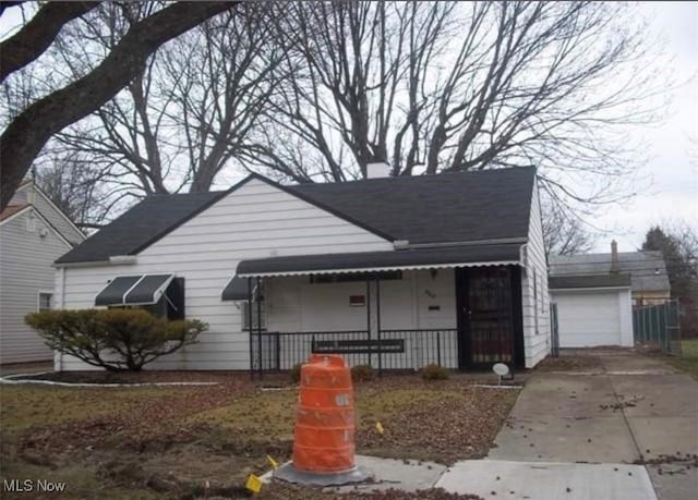 view of front of home with a garage, concrete driveway, and an outdoor structure