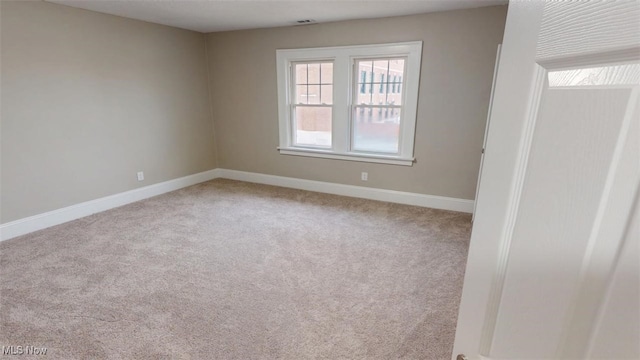 carpeted empty room with visible vents and baseboards