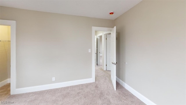 unfurnished bedroom with light carpet and baseboards