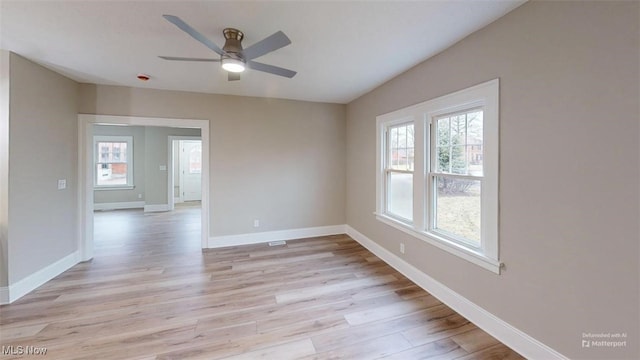 unfurnished room with light wood finished floors, baseboards, and a ceiling fan