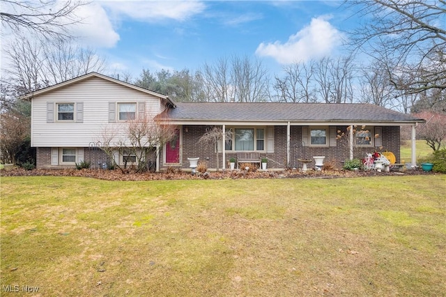 split level home with a porch, brick siding, and a front lawn