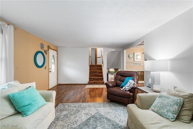 living area with stairway, wood finished floors, and baseboards