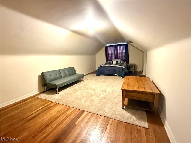 bedroom featuring vaulted ceiling, baseboards, and wood finished floors