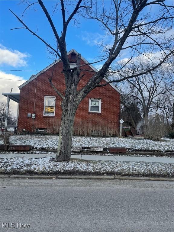 view of snow covered exterior featuring brick siding