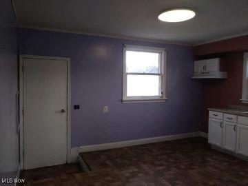 kitchen featuring baseboards and white cabinets