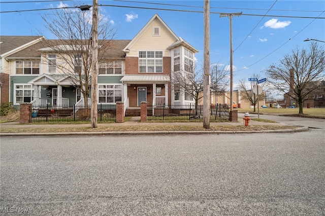 view of property with a fenced front yard and brick siding