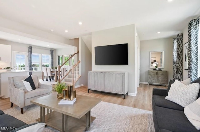 living room with light wood-type flooring, stairway, baseboards, and recessed lighting