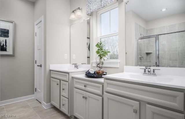 bathroom with a stall shower, plenty of natural light, a sink, and double vanity