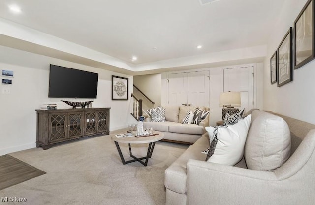 carpeted living area featuring recessed lighting, baseboards, and stairs